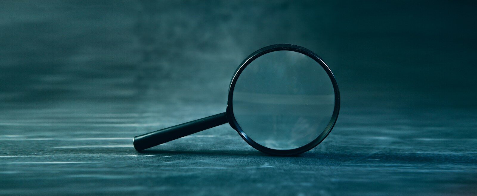 A magnifying glass rests on a textured surface